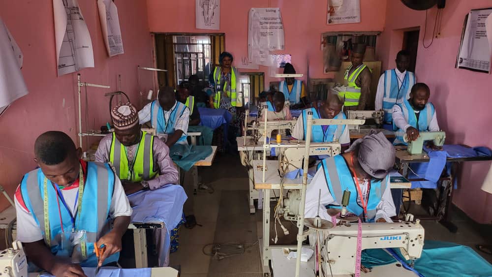 Trainees at industrial sewing machines during the 3-week tailoring seminar